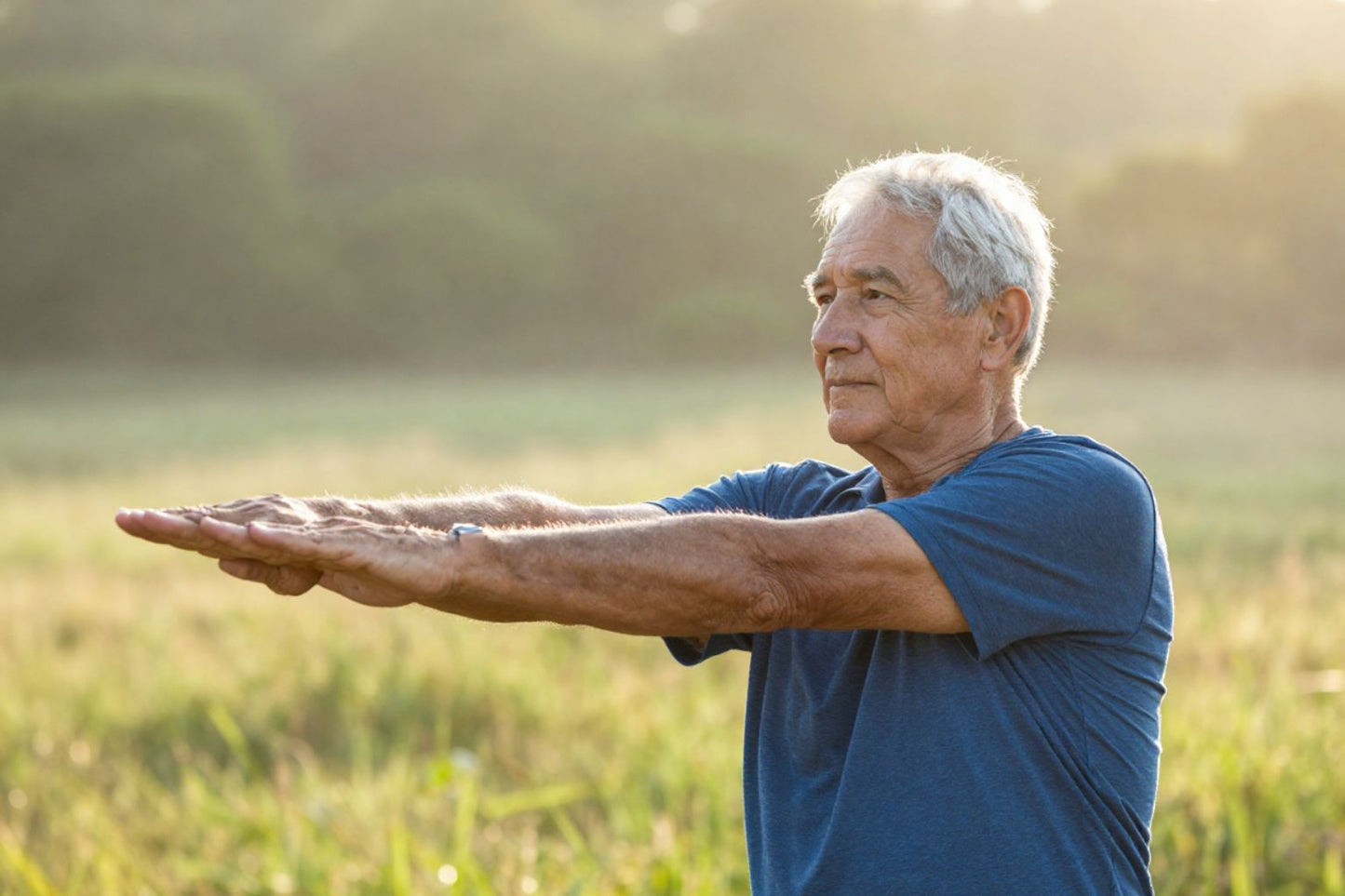 An active elderly man in his 70s stretching outdoors in morning light, surrounded by nature, looking calm and energized, photorealistic, warm sunrise tones, shallow depth of field